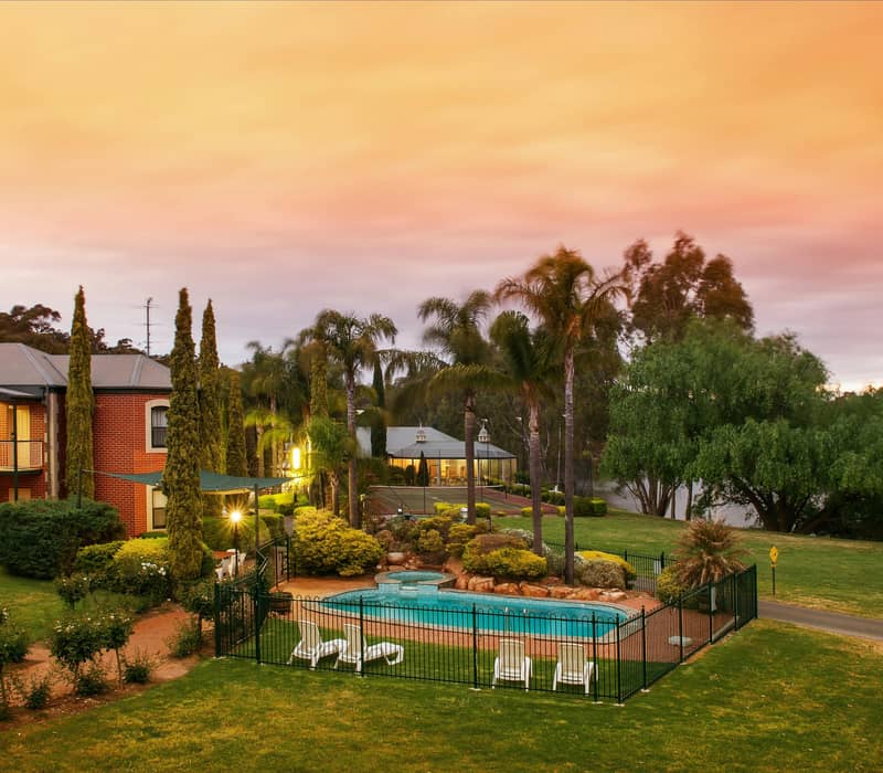 The interior of a contemporary guest room at the Clare Country Club, showcasing crisp white linens, neutral tones, and modern furnishings designed for a relaxing stay in South Australia's wine country.