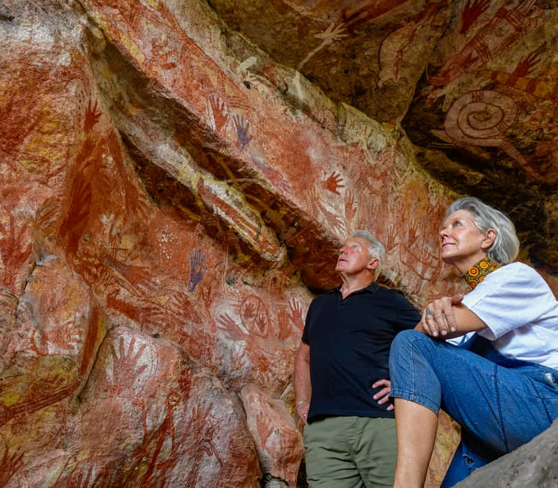 Visitors explore the ancient Aboriginal rock art galleries at Mt Borradaile, a sacred site in the Northern Territory's Arnhem Land featuring thousands of years of Indigenous cultural history.